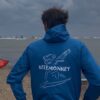Kitemonkey windproof kitesurf jacket in electric blue worn after a kitesurf session on the beach